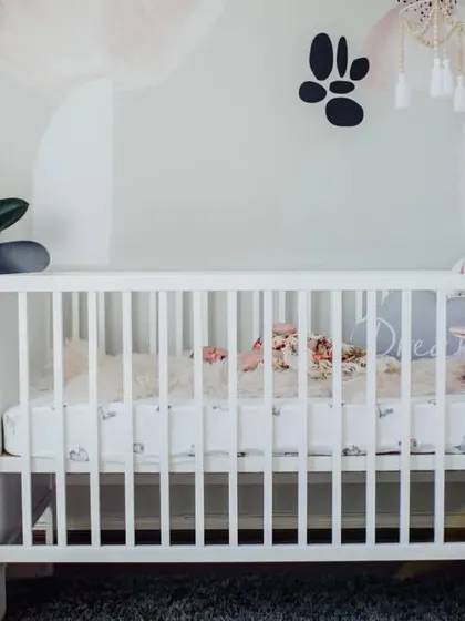 A wide view of a baby's nursery, with the newborn sleeping peacefully in a white crib. We can capture the beautiful space you have created for your little one.