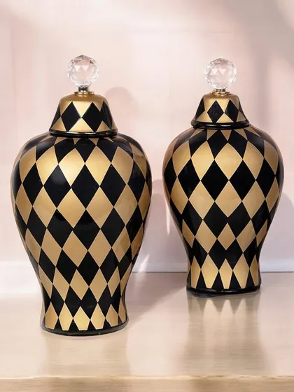 These bold ceramic jars feature a black and gold harlequin pattern and a crystal knob on the lid. They are glamorous and modern, perfect as standalone showpieces or for decorative storage.