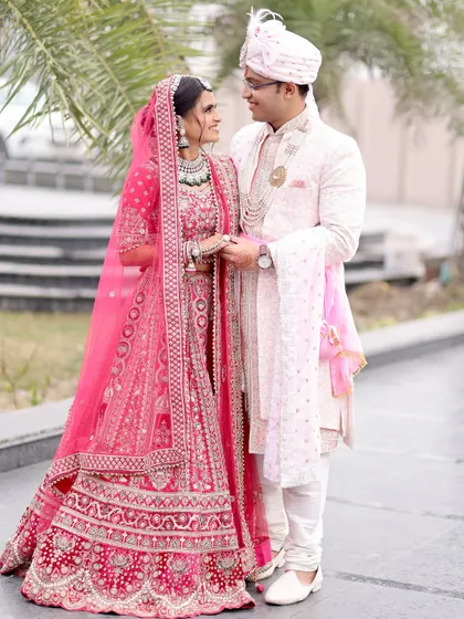 A sweet and classic wedding pose, with the couple holding hands and looking at each other, their smiles reflecting the happiness of their special day.