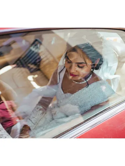 A candid moment of the bride in her wedding car. These in-between moments are just as important as the main events.