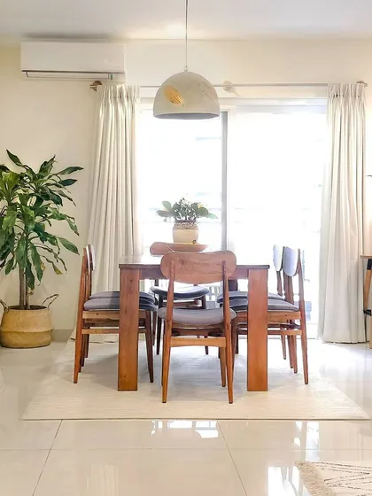 For the dining room in the JWD Marq Home, I kept the design simple and functional. A solid wood dining set is paired with a concrete pendant light and plenty of plants to create a bright and natural space for meals.