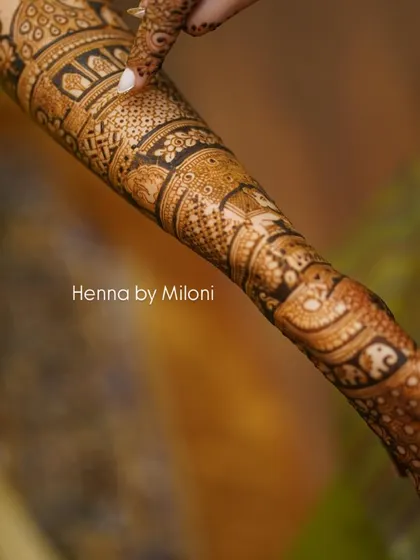 A detailed close-up of a bridal arm, showcasing the fine line work and shading.