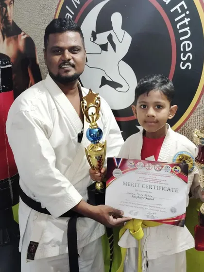 This yellow belt student celebrates his second-place win with two trophies, a great accomplishment for a young practitioner.