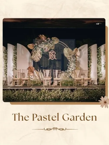 This "Pastel Garden" stage combines rustic and modern elements for a soft, romantic feel. A custom monogram is framed by a delicate arch of pampas grass and pastel florals, creating a personalized and chic setting.