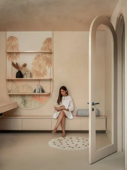 The arched passageway leads from the living area to the study, with the client's own hand-painted artwork creating a personal and artistic transition between the spaces.