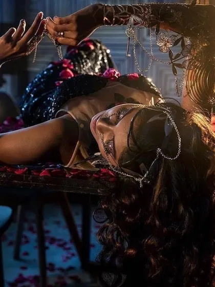 A highly conceptual shot from a lighting workshop. The styling involved intricate jewellery, a shoulder band, and rose petals to create a dark, romantic, and editorial scene.