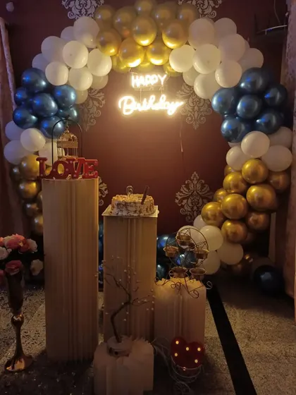 A classic birthday decoration with a blue, white, and gold balloon arch, perfect for creating a festive atmosphere.
