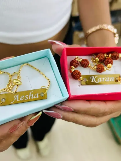 A matching set of personalized bracelets for a brother and sister, presented in cute gift boxes. One features an adjustable chain and the other has rudraksh beads.
