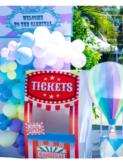 A carnival ticket booth and a hot air balloon prop welcomed guests to this whimsical pastel-themed party.