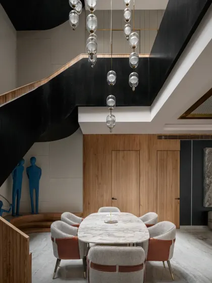 The dining area in The House of Dancing Screens opens into a triple-height cut-out. This, along with a gently curving stairway, allows natural light to flood all three floors throughout the day.