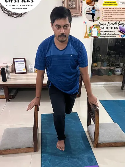 Using chairs for support, this client works on a single-leg balance exercise. This is an excellent way to build stability and leg strength, crucial for functional fitness.