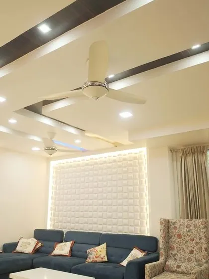A view of the living room's false ceiling, which features dark wooden beams and both cool and warm LED lighting. This design adds architectural interest and allows for varied mood lighting.