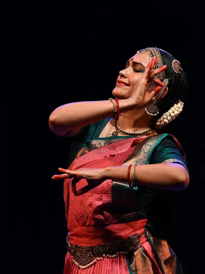 An intimate, close-up shot of a dancer's expressive face and hands. This highlights the 'abhinaya', or emotional storytelling, aspect of Bharatanatyam.