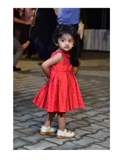 Bianca's little sister in a sweet raw silk Ikat frock. The pleated design and simple bow detail make it a comfortable and cute choice for a party.