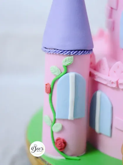 The fine details matter, like the tiny fondant roses climbing up the castle tower, giving it a storybook feel.