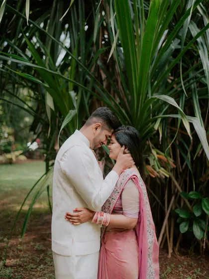 An intimate embrace in a lush, green setting during an engagement photoshoot.