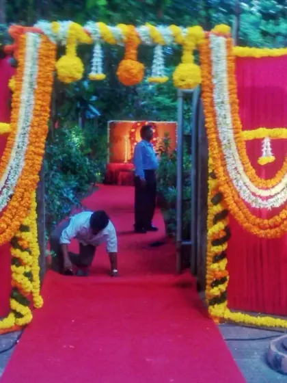A traditional entrance gate decorated with yellow and white marigold garlands. This type of decoration is perfect for weddings, poojas, or festive celebrations.