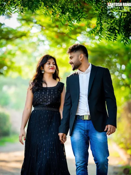 A stylish shot of a couple walking down a tree-lined path, capturing a candid moment.