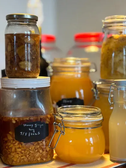 A closer look at our ferments, including a jar of our honey-ginger bug dated for 2025. This shows the patience and care that goes into crafting each batch of our natural drinks.