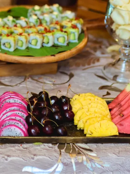 This display pairs a platter of exotic fruits like dragon fruit, cherries, and pineapple with a board of our fresh vegetarian sushi, offering a unique combination of sweet and savory flavors.