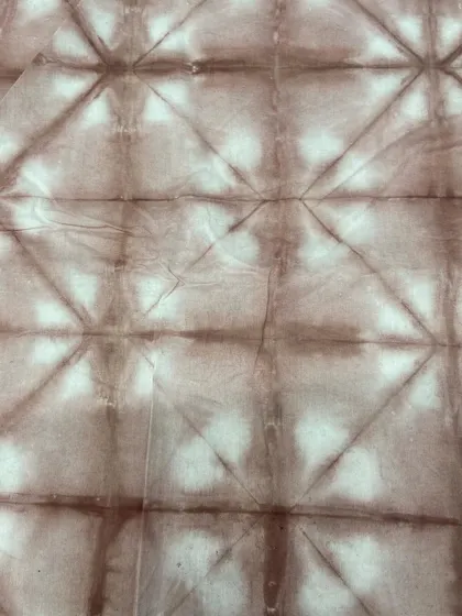 A diamond grid pattern, created by folding the fabric on a diagonal before tying and dyeing.