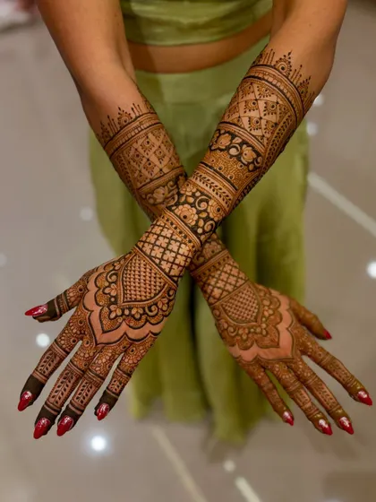 A crossed-hands pose of the wedding mehendi, highlighting the beautiful patterns.