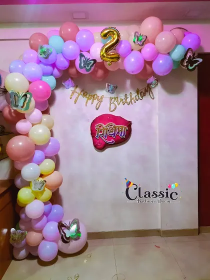 Another beautiful butterfly-themed balloon arch in pastel colors for a 2nd birthday celebration at home.