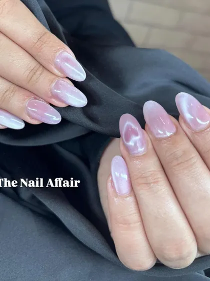 A soft and ethereal cat eye effect in a light pink, pearly shade on almond-shaped nails.