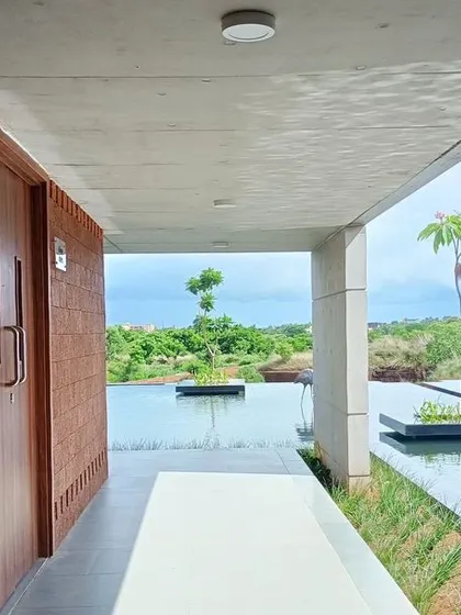 A corridor at the Bagchi Karunashraya hospice overlooks a large water body, blurring the line between inside and outside. The design is intended to provide a serene atmosphere for residents.