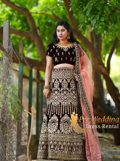 A full shot of the dark velvet lehenga in a natural setting, showing its regal silhouette.
