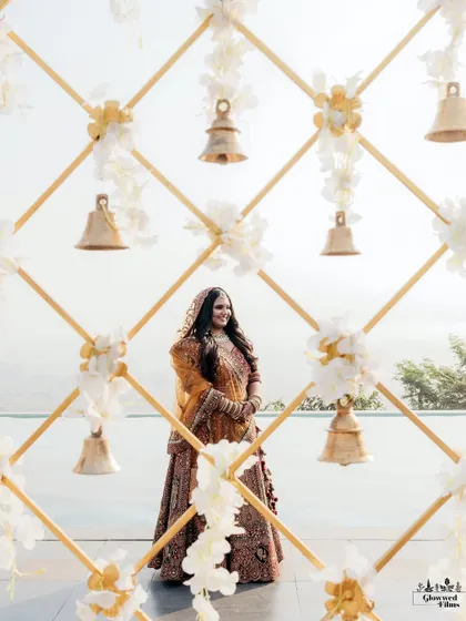 A beautiful portrait of the bride, Namita, framed by a decorative wall of bells, her smile as bright as the sun.