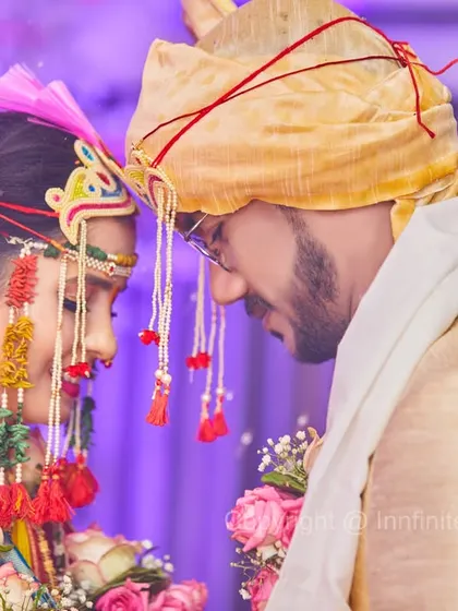 The traditional Maharashtrian headwear, the Mundavalya, is a beautiful detail. This intimate close-up highlights both the tradition and the couple's connection.
