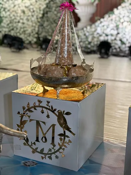 A personalized offering box with a custom monogram, adding a modern touch to the traditional setup.