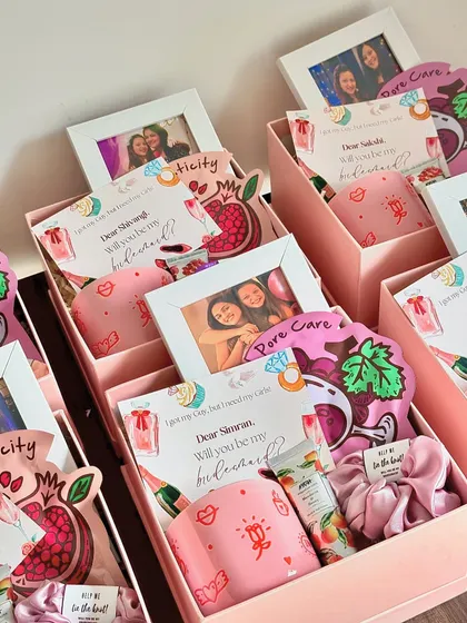 Inside these bridesmaid boxes, I've included a custom-printed mug, a personalized photo frame, hand cream, a face mask, and a scrunchie.