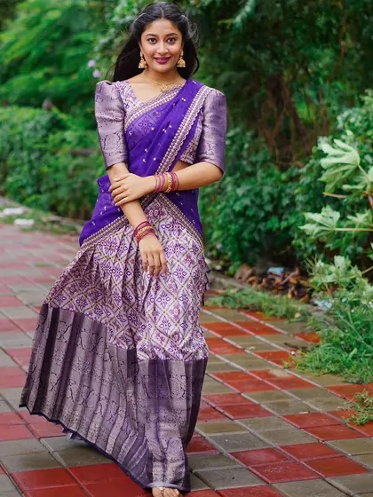 This full-length shot shows the beautiful flow of the patola print half saree, a perfect outfit for a daytime event or a festive celebration.