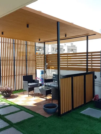 Here we built a complete outdoor room under a pergola, with slatted wood screens for privacy and a checkerboard deck for the seating area. It’s a perfect example of creating a defined, functional zone on a large terrace.