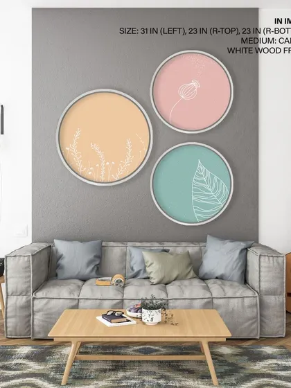 A playful set of three circular prints with minimalist floral and leaf line drawings. The white wood frames and pastel backgrounds create a light, cheerful, and modern gallery wall.