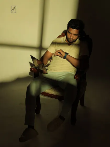 A pose that interacts with the light and shadow, as if the subject is checking the time in a sliver of sunlight.