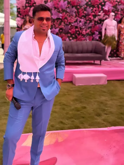 A full-length shot of the blue suit against a vibrant pink floral backdrop. I love when my outfit complements the event's color scheme.