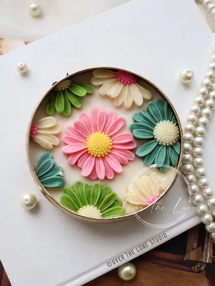 I love how the bright pink daisy pops against the green and ivory flowers in this urli design. It's a perfect example of how I play with color to create something truly special.