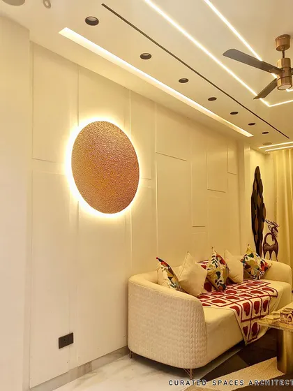 Lighting is key to setting the mood. This backlit circular art piece acts as a modern focal point on the paneled wall, adding a warm and artistic glow to the living room.