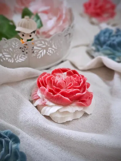 A single pink and white Peony candle, showcasing its intricate design. These candles are beautiful enough to be used as decor pieces on their own, adding a soft, floral touch to any room.