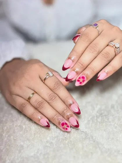 A variation of the maroon floral design, this time on a French tip base. This shows how a single art concept can be adapted into different styles.
