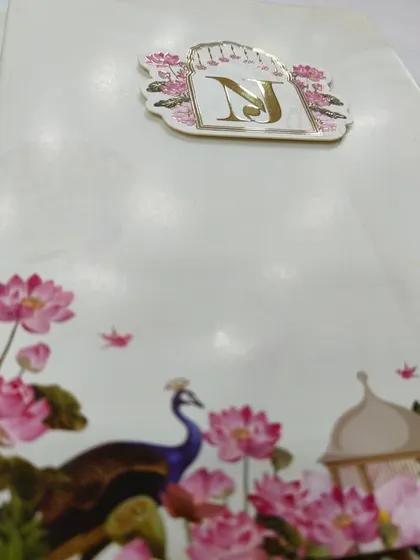 A detailed shot of the Pichwai artwork on one of my invitations, showing the delicate lotus flowers, peacocks, and the custom initial tag.