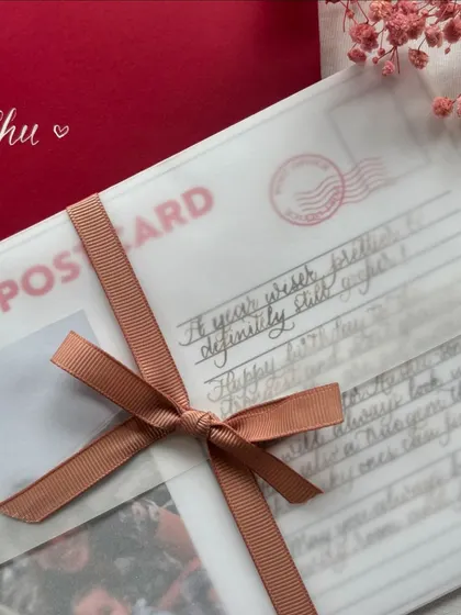 A lovely postcard birthday letter is a wonderful way to send your love. This design includes a personal polaroid photo and a handwritten message, all wrapped in a vellum sheet and tied with a ribbon.