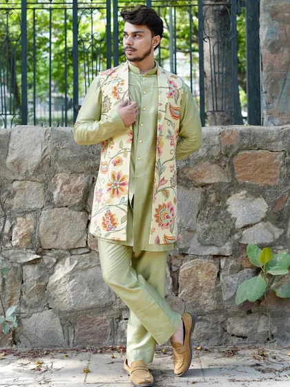 A full-length view of a light green kurta set paired with a longline floral printed Nehru jacket. This is a perfect ensemble for a daytime wedding or a garden party.