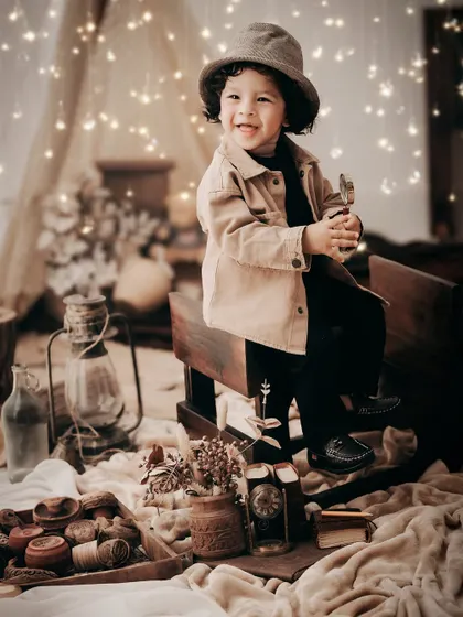 A moody and atmospheric camping-themed shoot. The warm glow of the fairy lights and lanterns creates a magical, cozy ambiance.