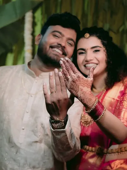 The couple joyfully showing off their new engagement rings to the camera.