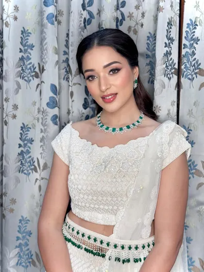 A full portrait of the bride in her white lehenga, with makeup that is both glamorous and elegantly understated.
