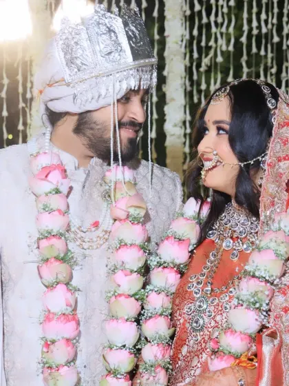 A close-up of the bride and groom sharing a look during their wedding ceremony, with beautiful lotus varmalas symbolizing their union.